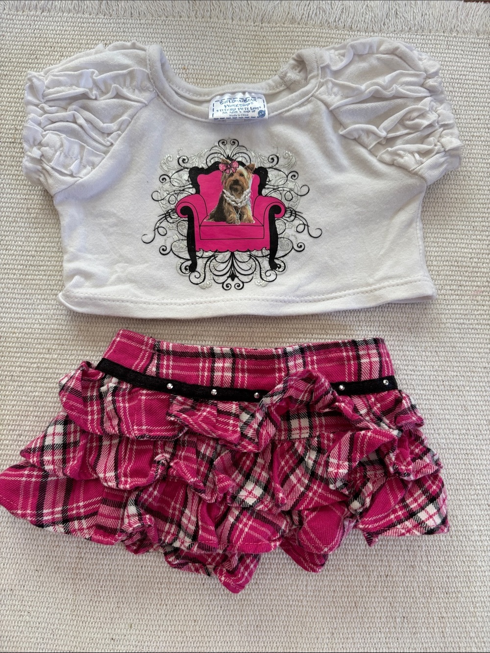 Build-A-Bear outfit featuring a graphic dog tee and a pink plaid ruffled skirt.